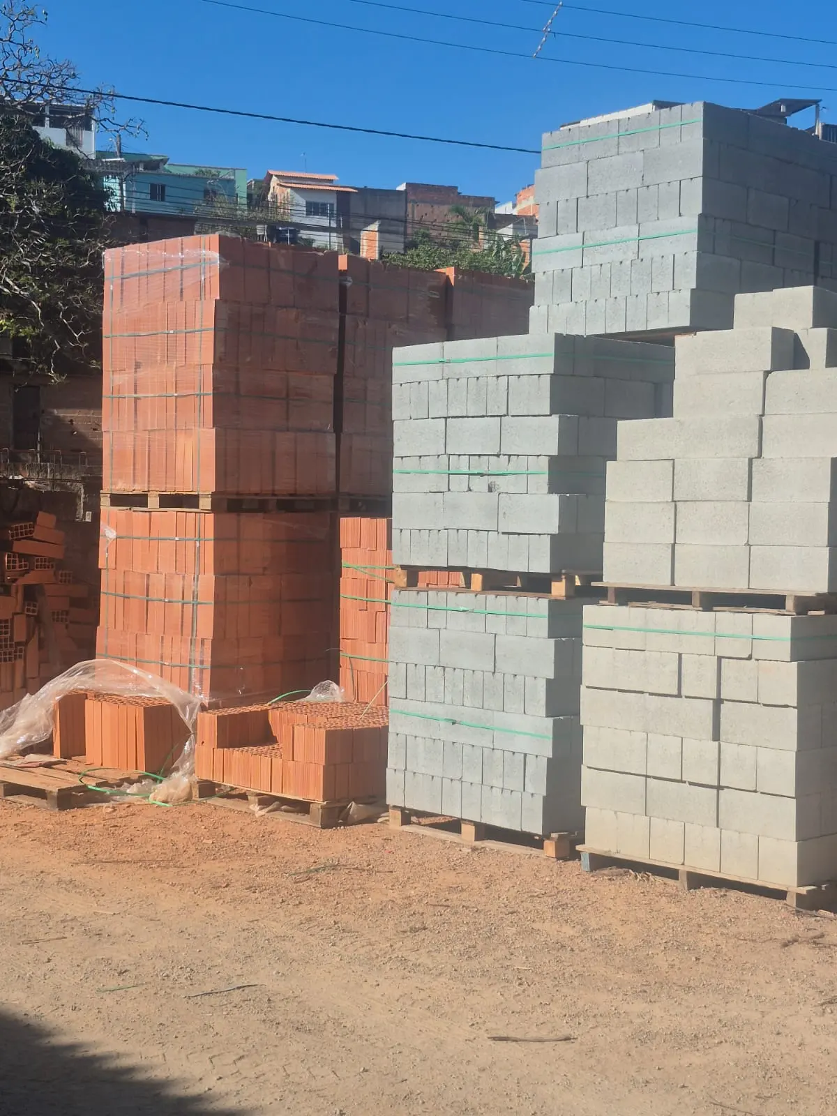 Pátio de materiais O Gaúcho, com tijolos cerâmicos e blocos de concreto empilhados